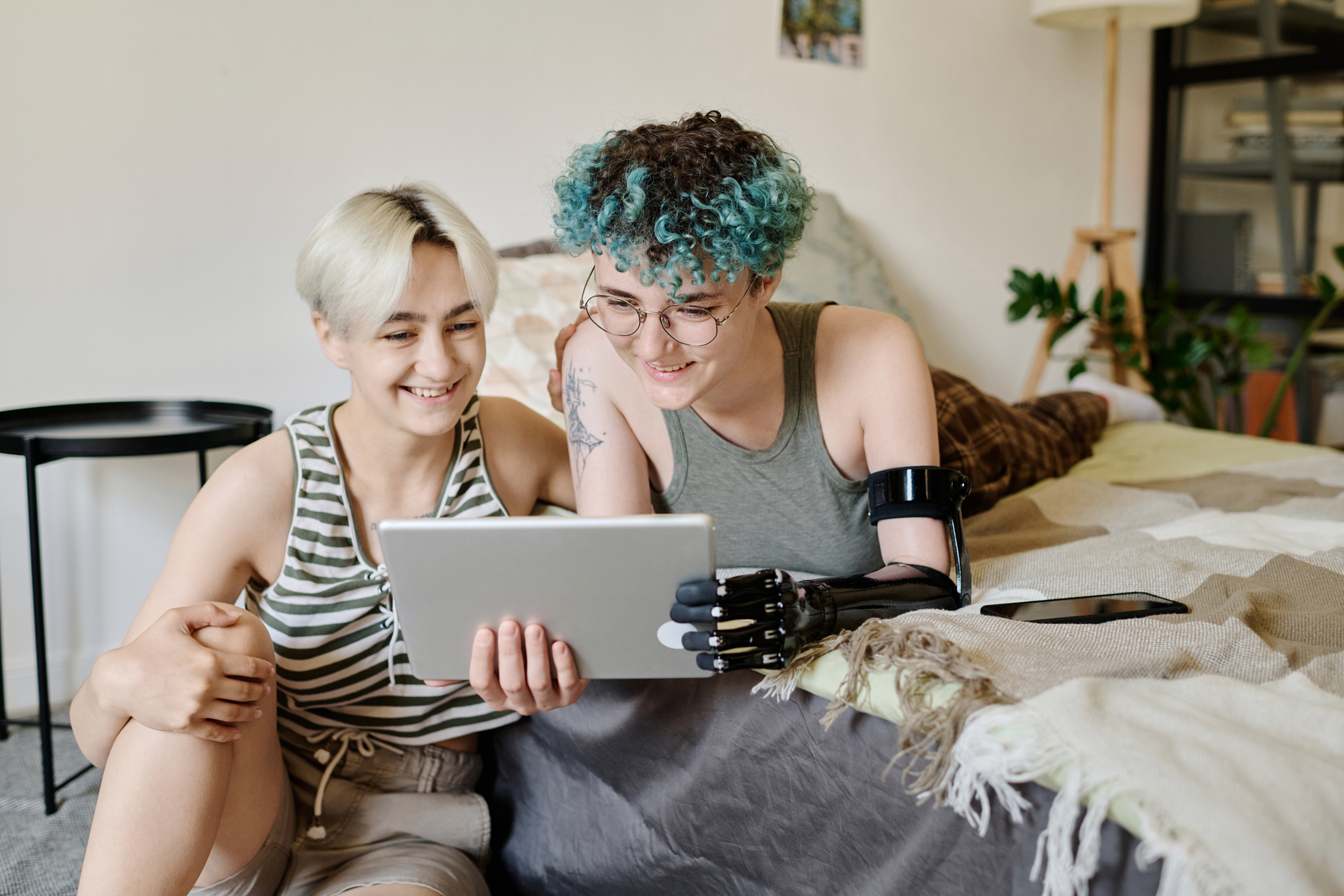 two young women using tablet computer at home