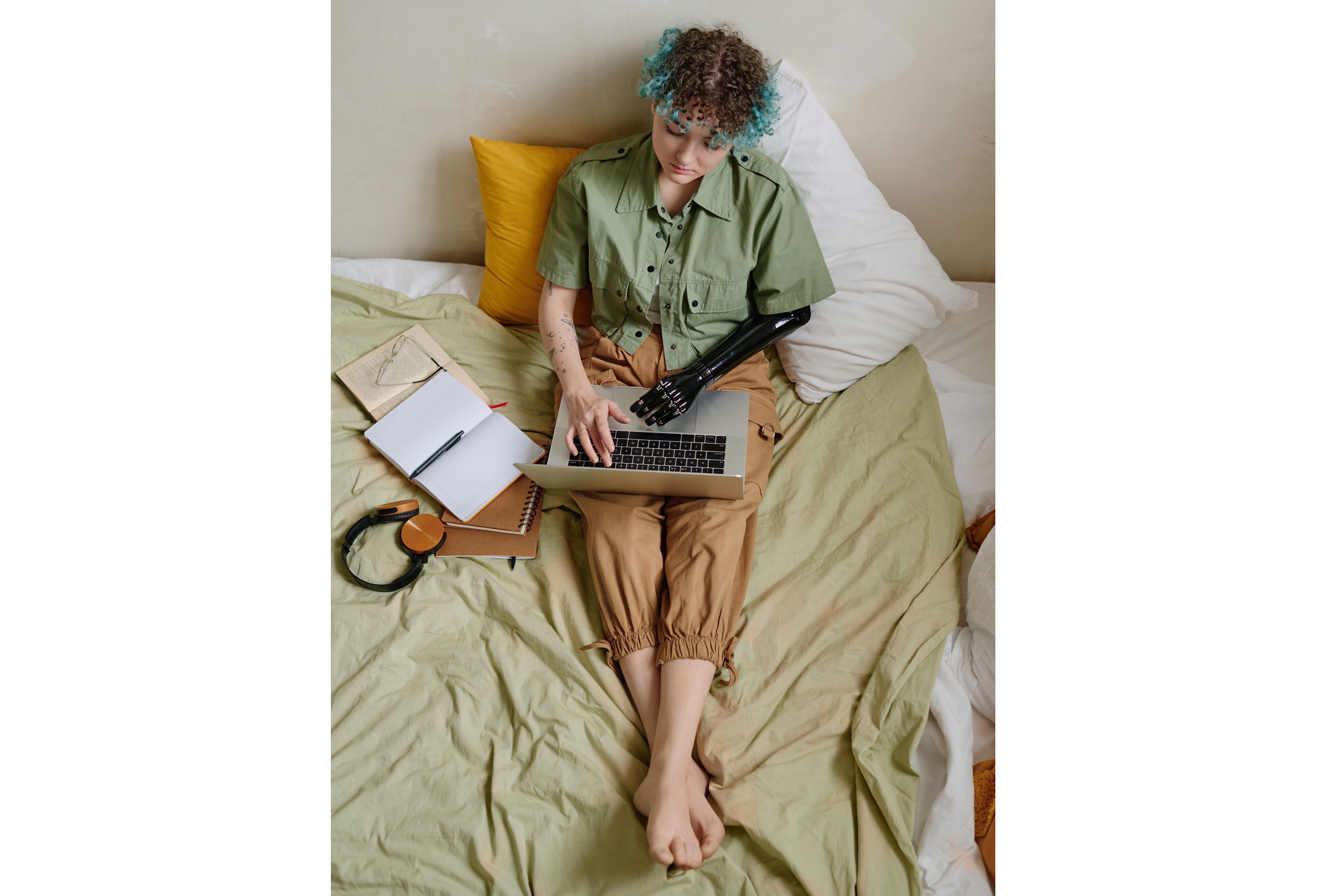 Girl with prosthetic arm Working on a Laptop in a Bedroom