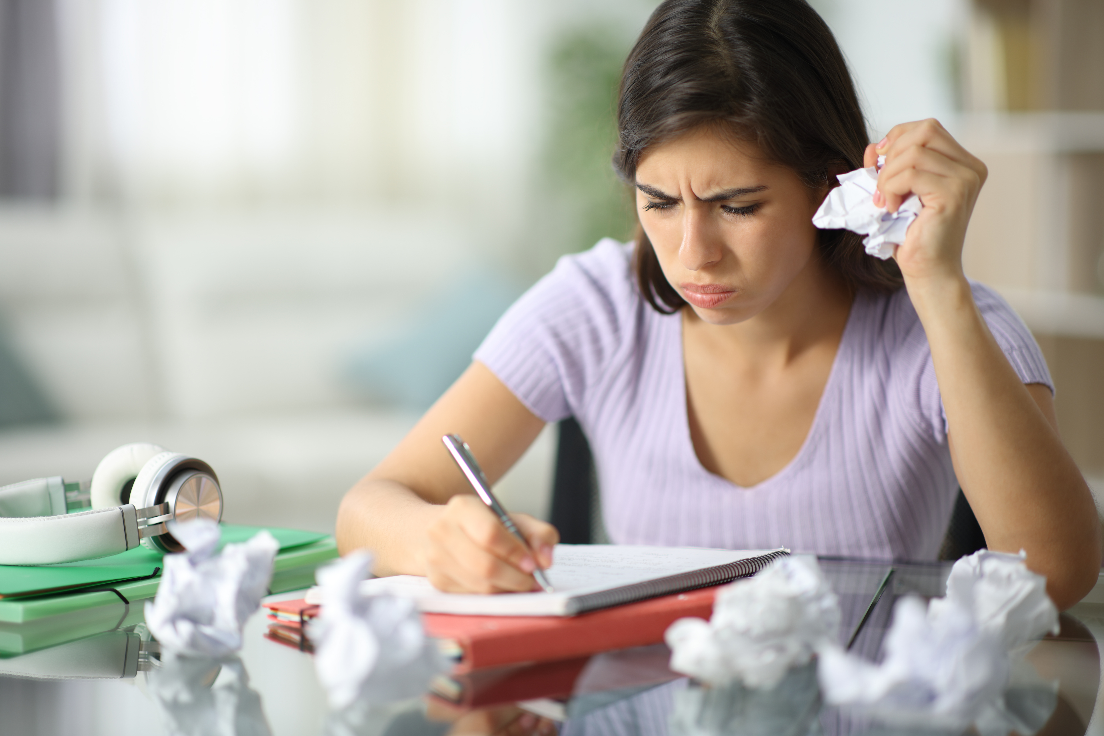 Frustrated female college student with ADHD crumples papers