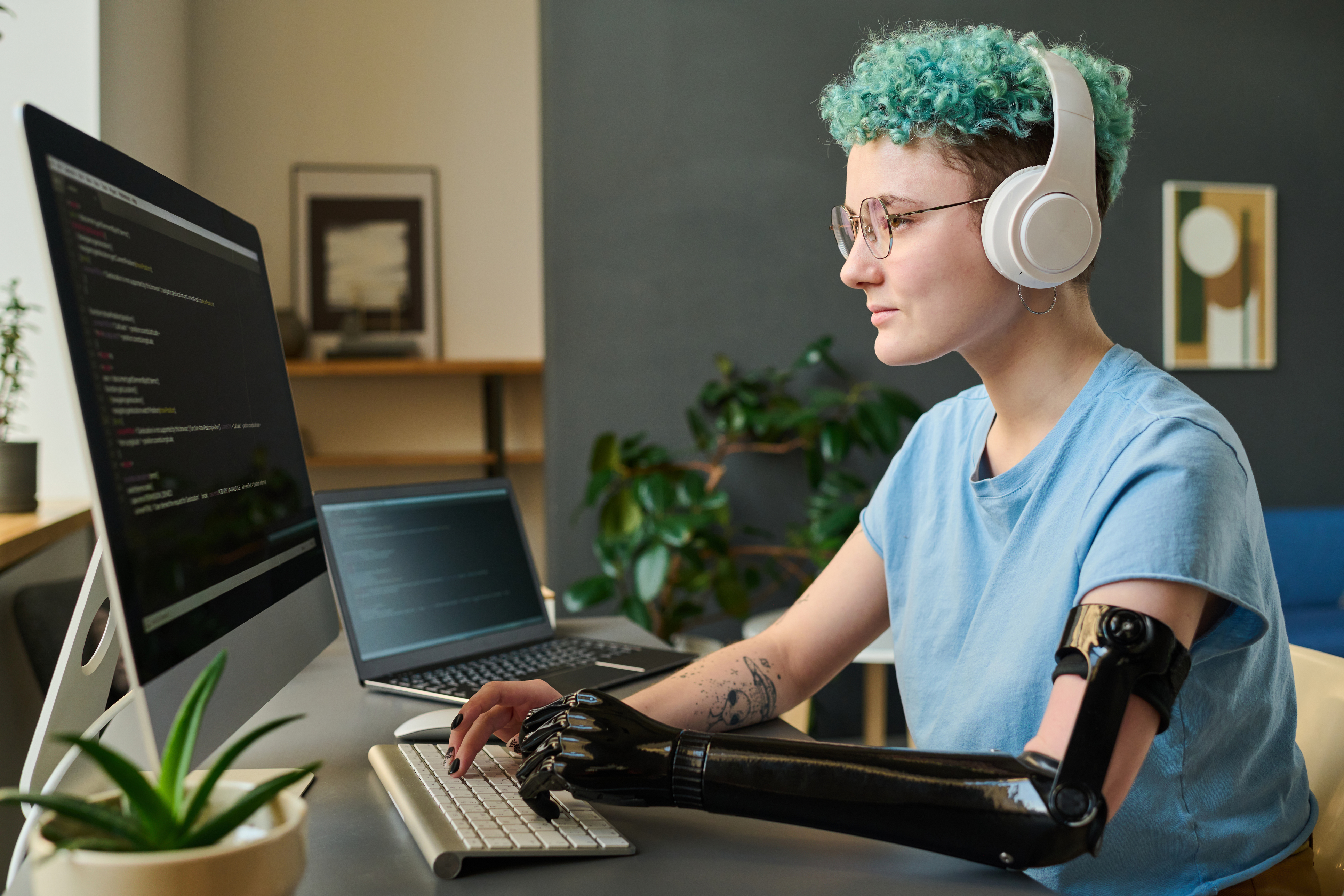 Young computer developer with a prosthetic arm typing on a computer