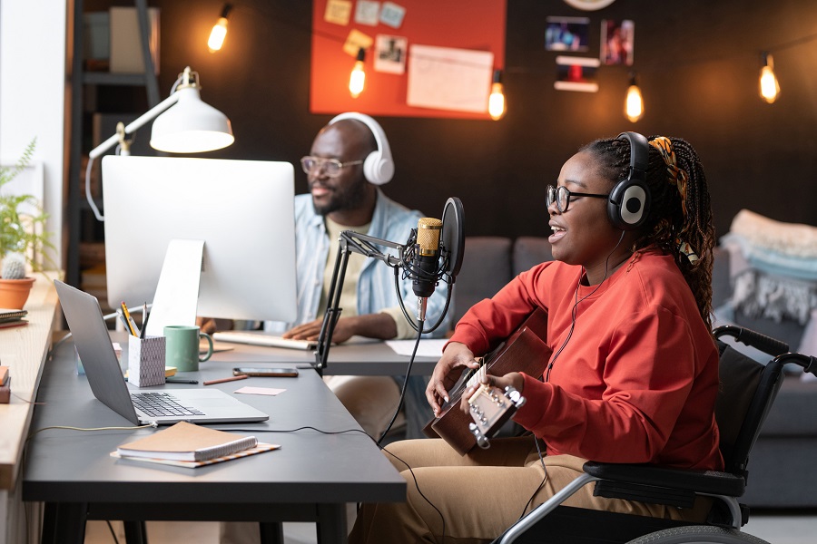 Black woman with disability recording a song in wheelchair
