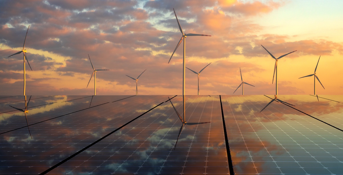 solar panels and wind turbines in front of a colorful, cloudy sky