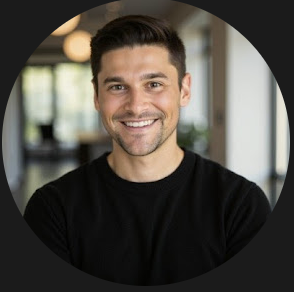 Man with short dark hair wearing a black s-shirt smiling