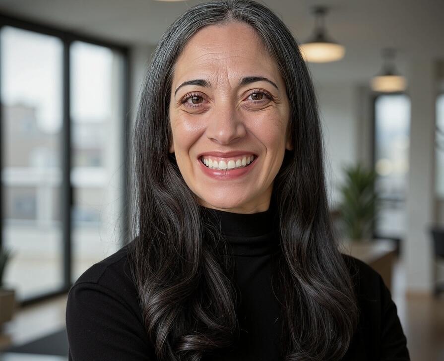 Andrea Day sitting in a black turtleneck smiling. 