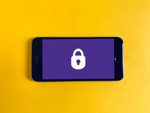smartphone with purple lock screen on top of a yellow background