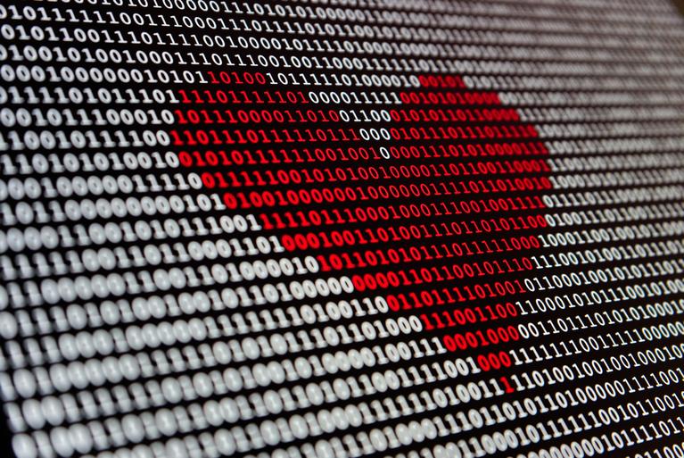 Red heart image made up of code on a laptop screen